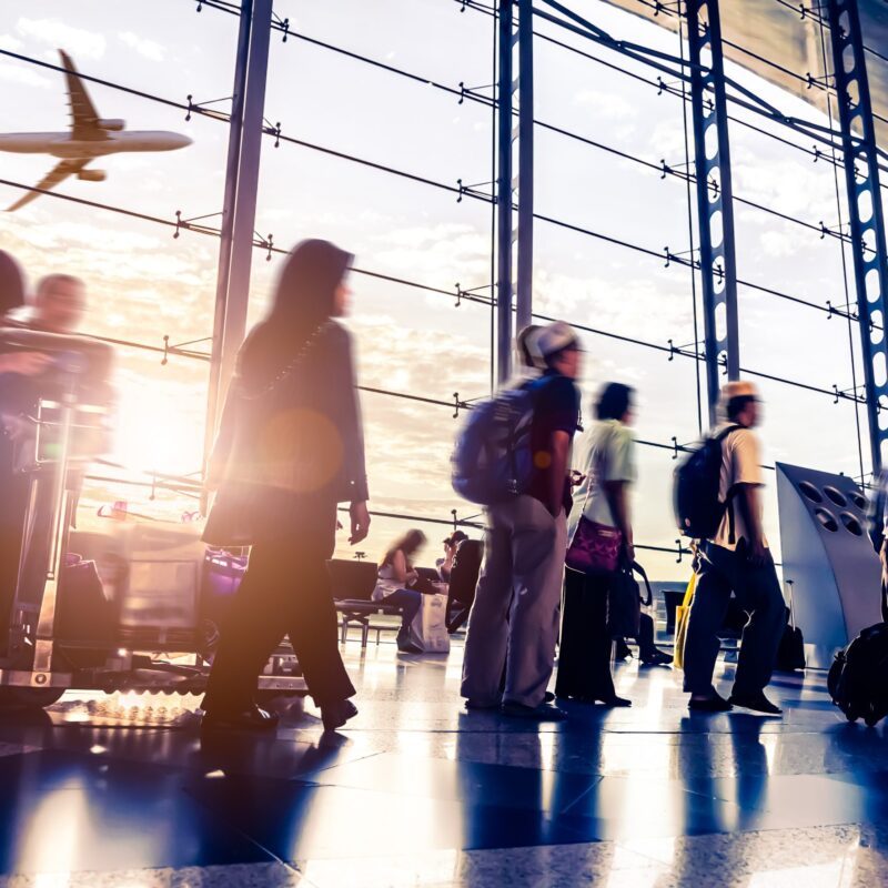 Busy airport with figures in motion and an airplane taking off