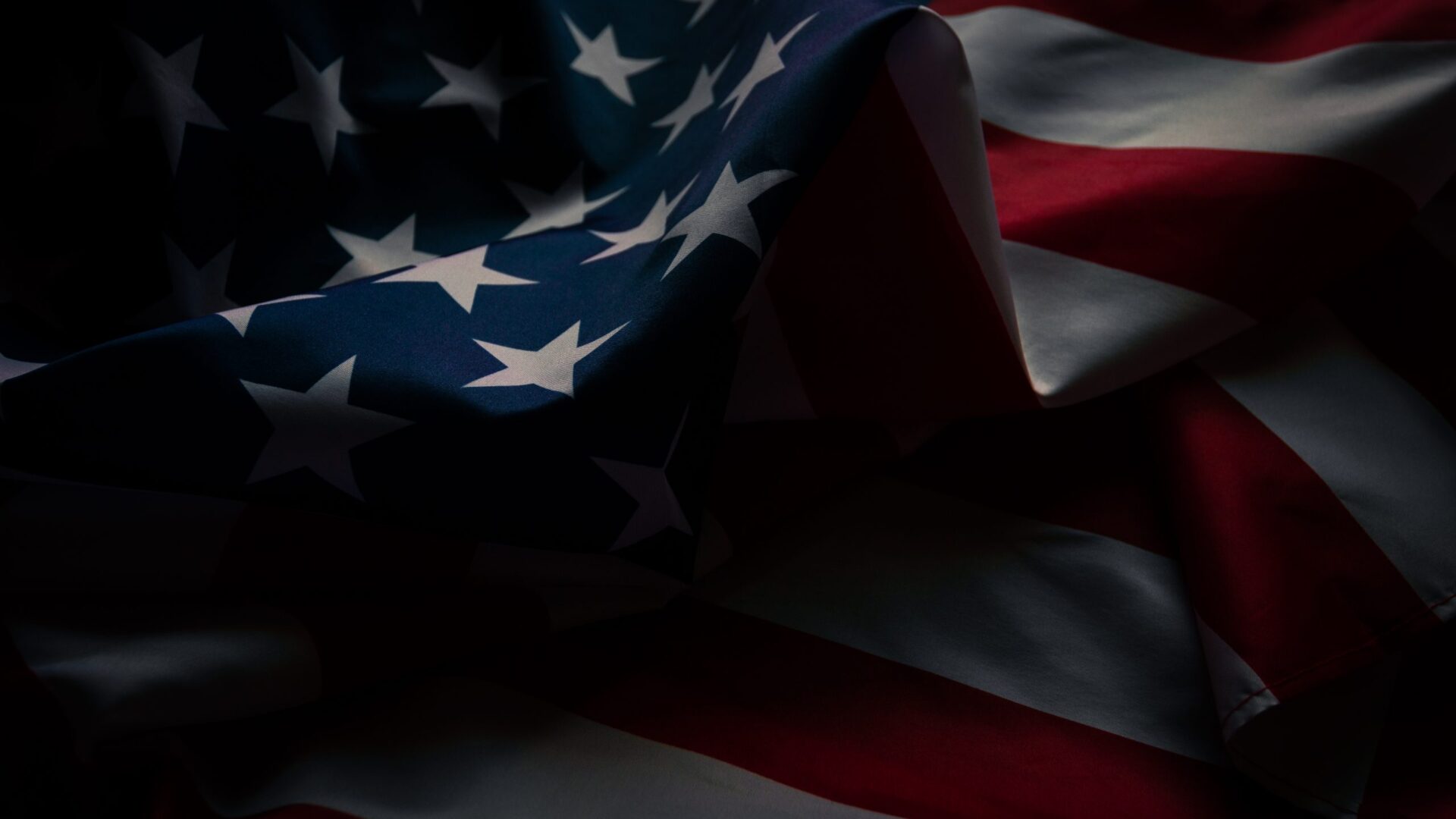 Close up of a waving American flag in shadow