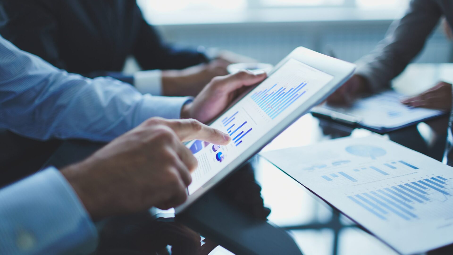 Business man points at graphs on an ipad